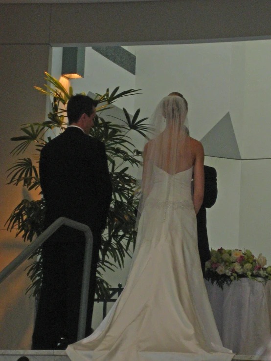 the bride and groom are standing in front of an altar