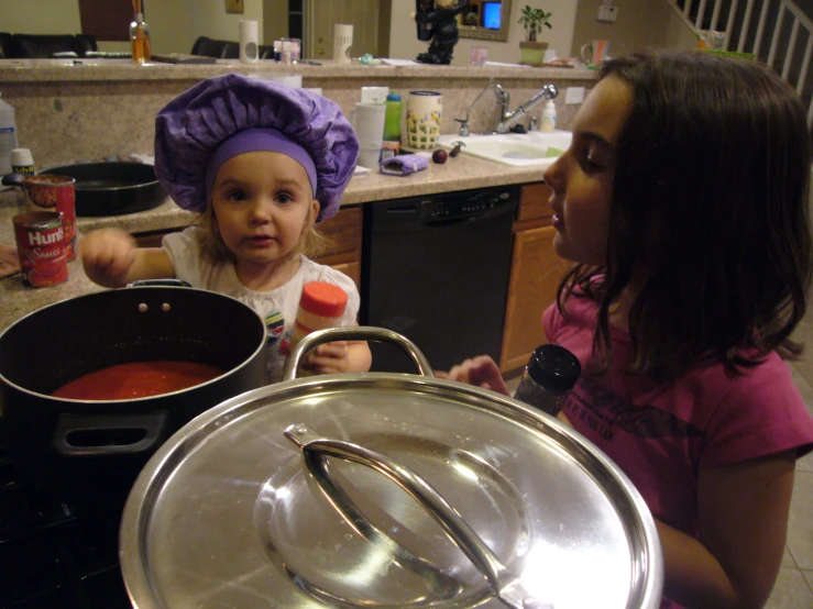 a woman and a little girl standing in a kitchen