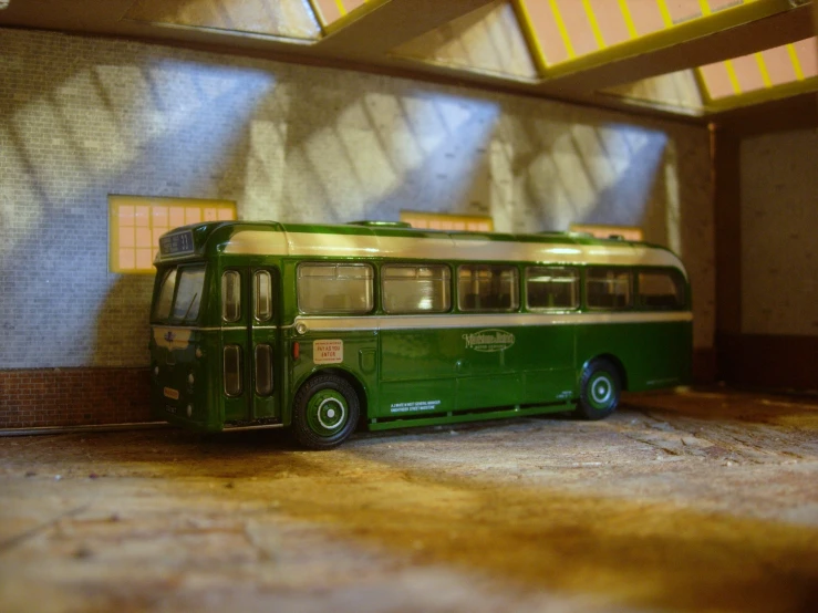 an old green bus is parked in a garage