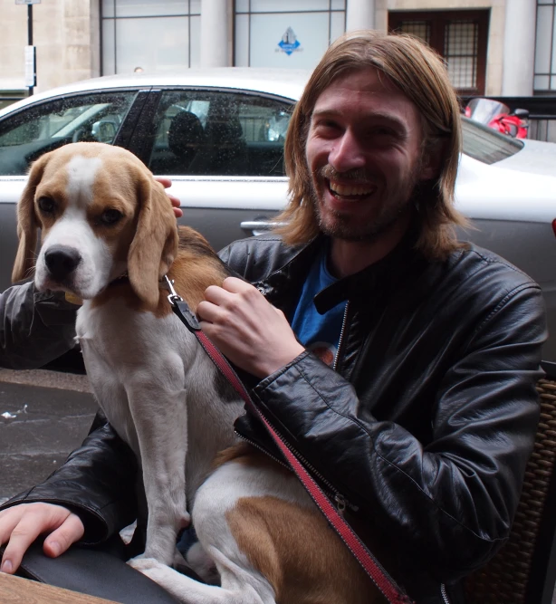 a man is petting his dog while sitting on a table