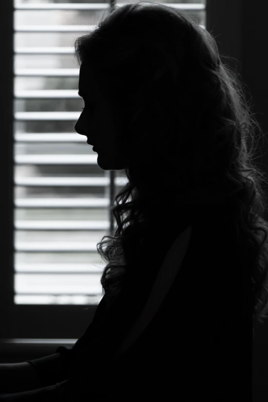 a woman that is standing in front of a window