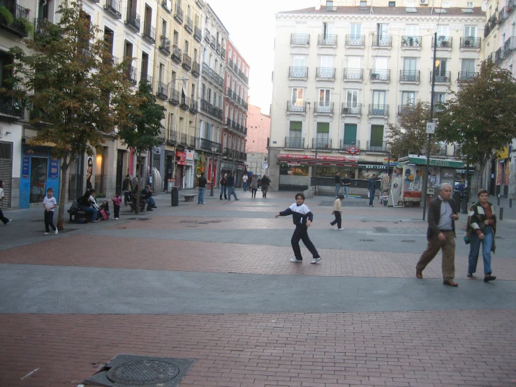 several people are playing on the street while others walk by