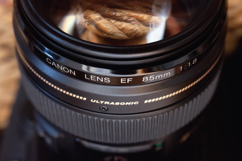 a camera lens is open to show a reflection in the glass