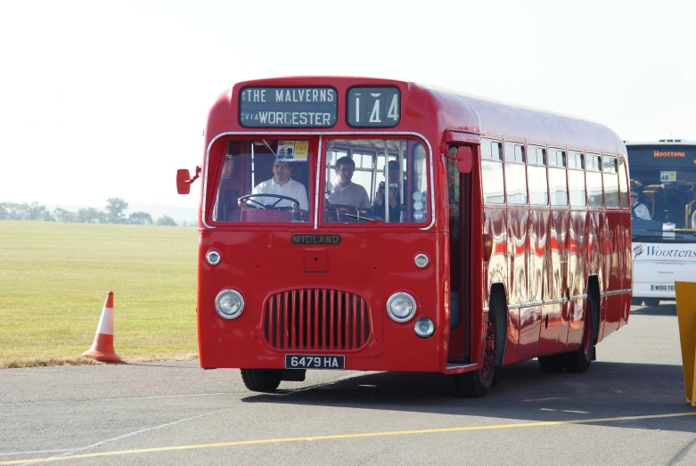 an old bus in the road with people riding on it