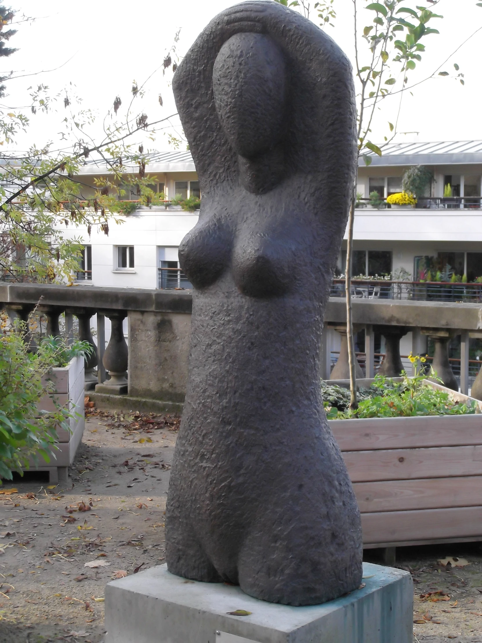 a large metal sculpture with a  woman in the background