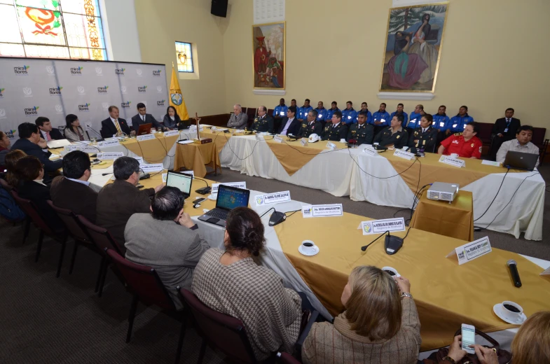 a meeting in a conference room with people sitting at the tables