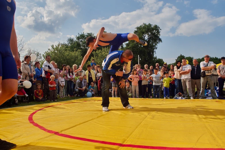 two men are performing a trick on a basketball court