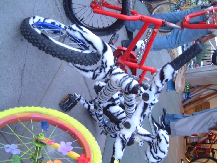 two bicycles decorated with bright fake flowers sitting on the ground