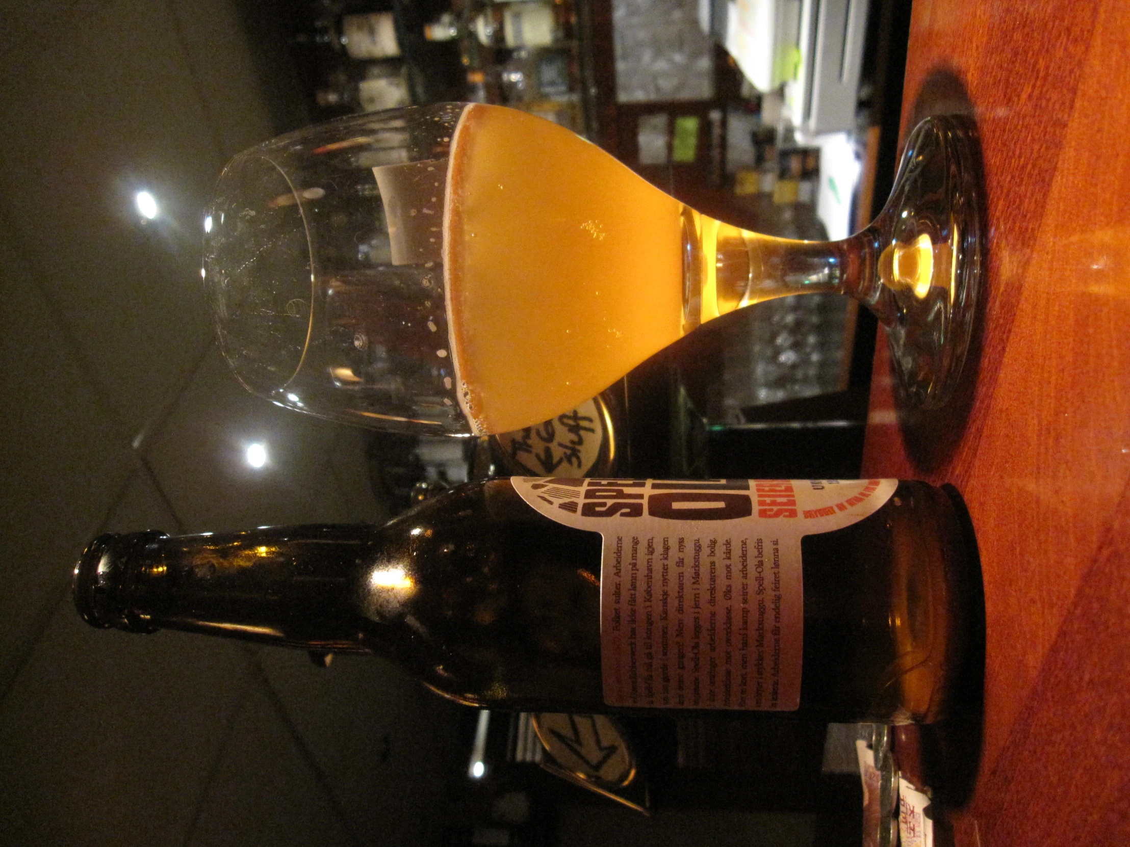 a beer bottle and glass on a wooden table