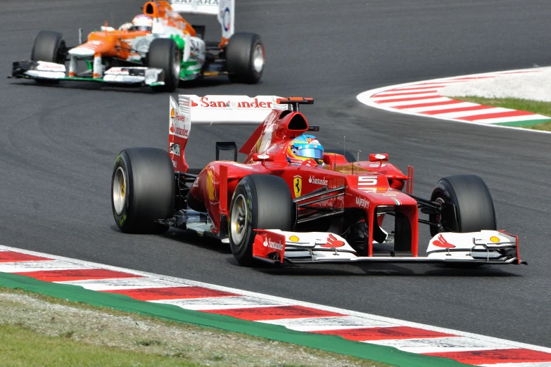 two people racing cars around a track on the grass