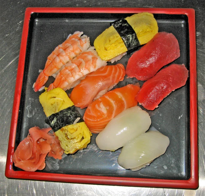 there are assorted sushi and chop sticks on this plate