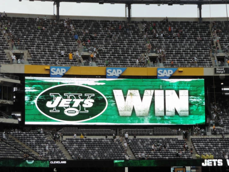 fans sit in bleachers and look out into the stands at the jets football game