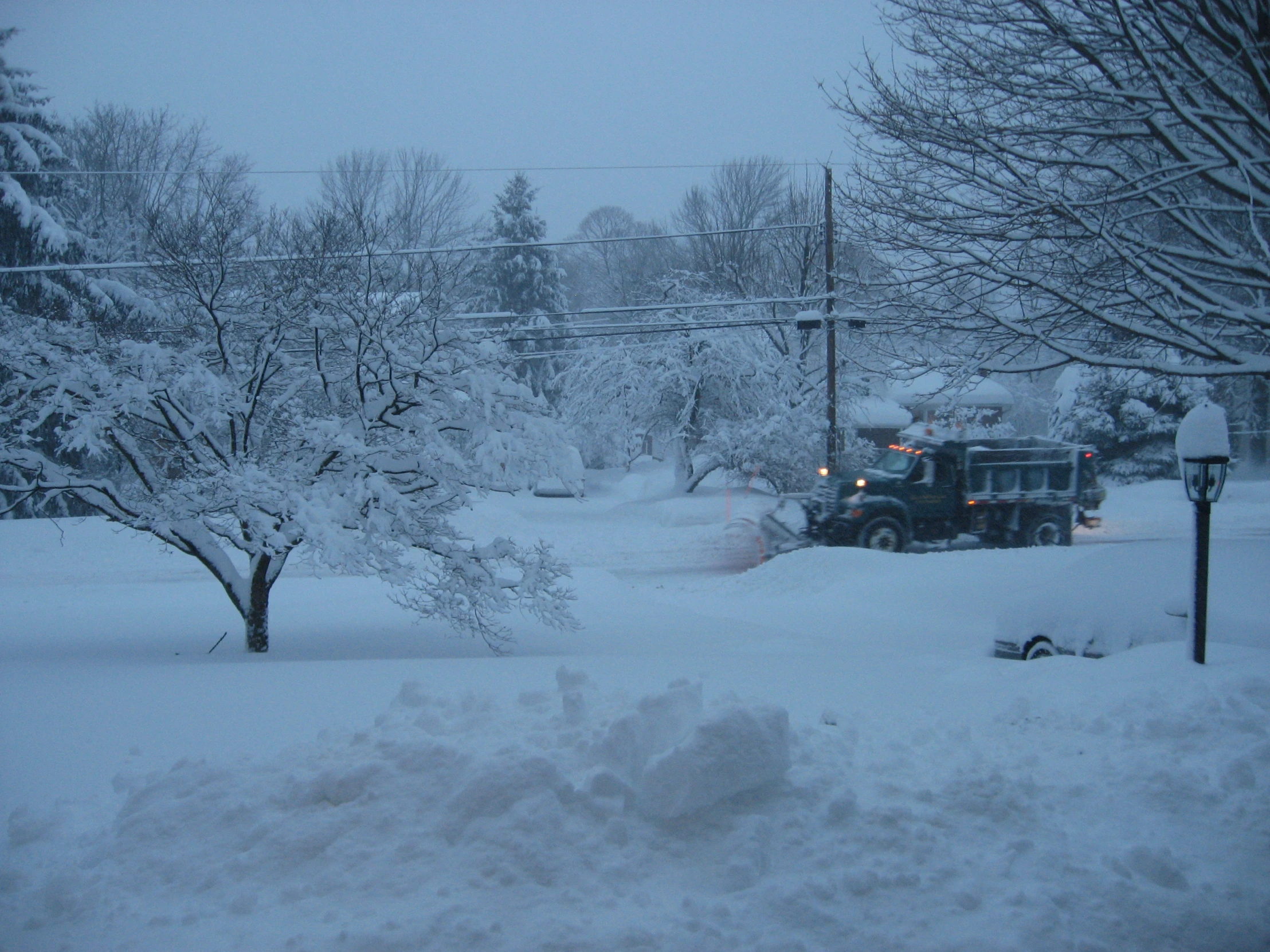 there is a snow plow that is traveling across the street