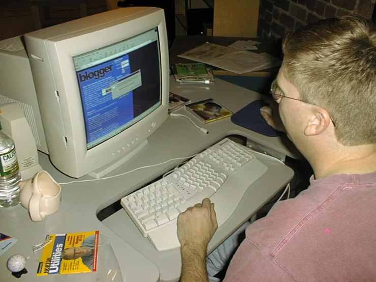 a man using a desktop computer at his desk