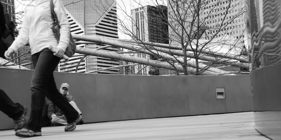 a woman walking down a city street next to tall buildings