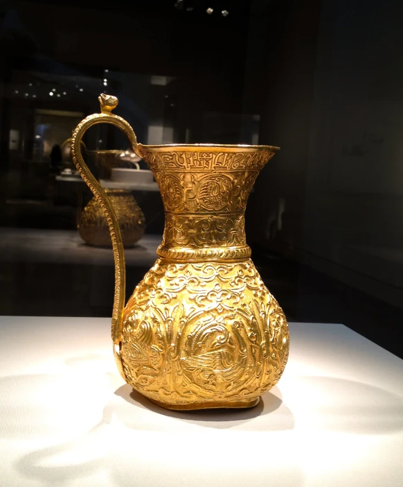 a glass cup with gold leaf designs on it