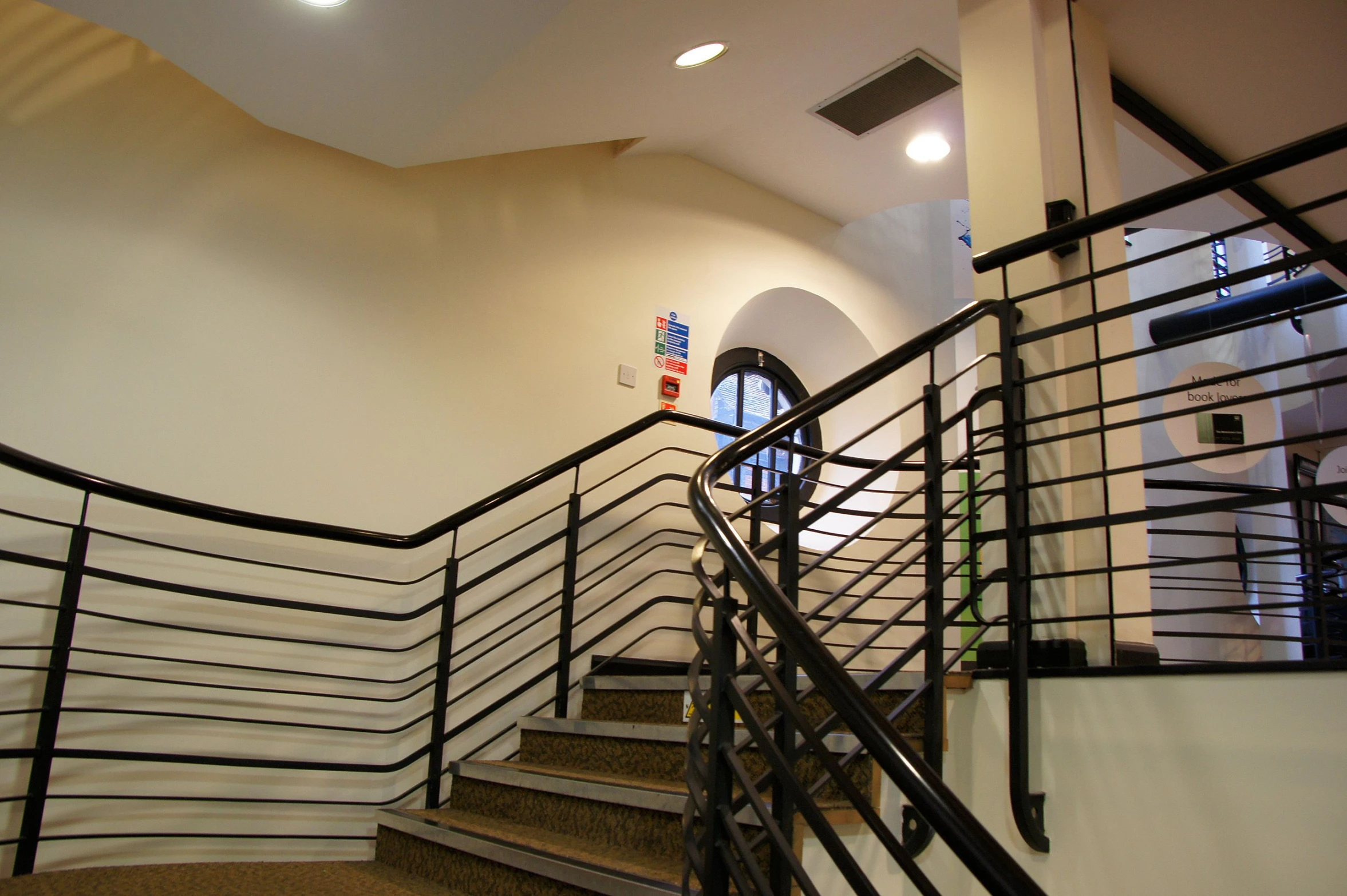 a building with an arch on the ceiling and stairs