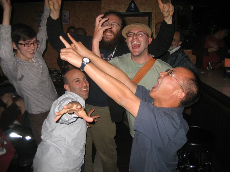 a group of friends making silly faces in a bar