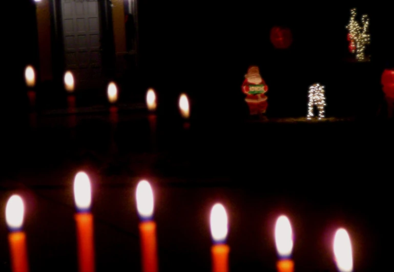 several lighted candles are in front of a christmas wreath
