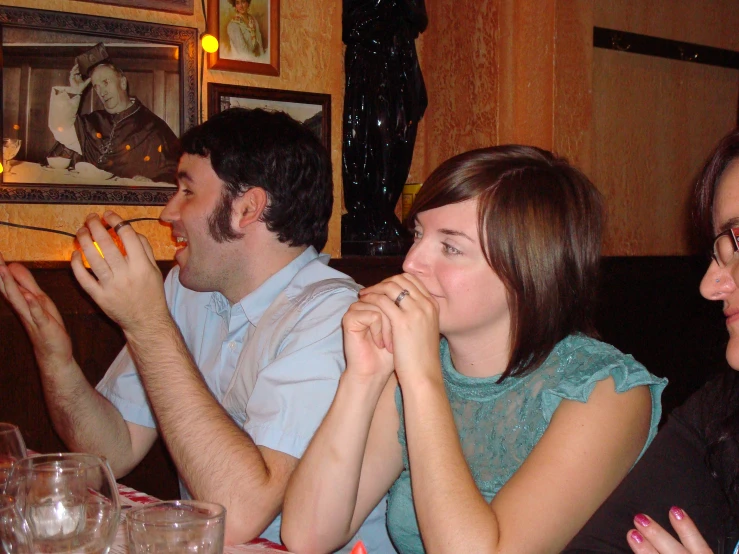 a woman and two men at a dinner table