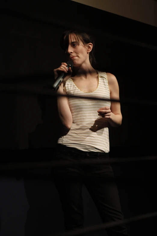 a woman in a white shirt holding a microphone