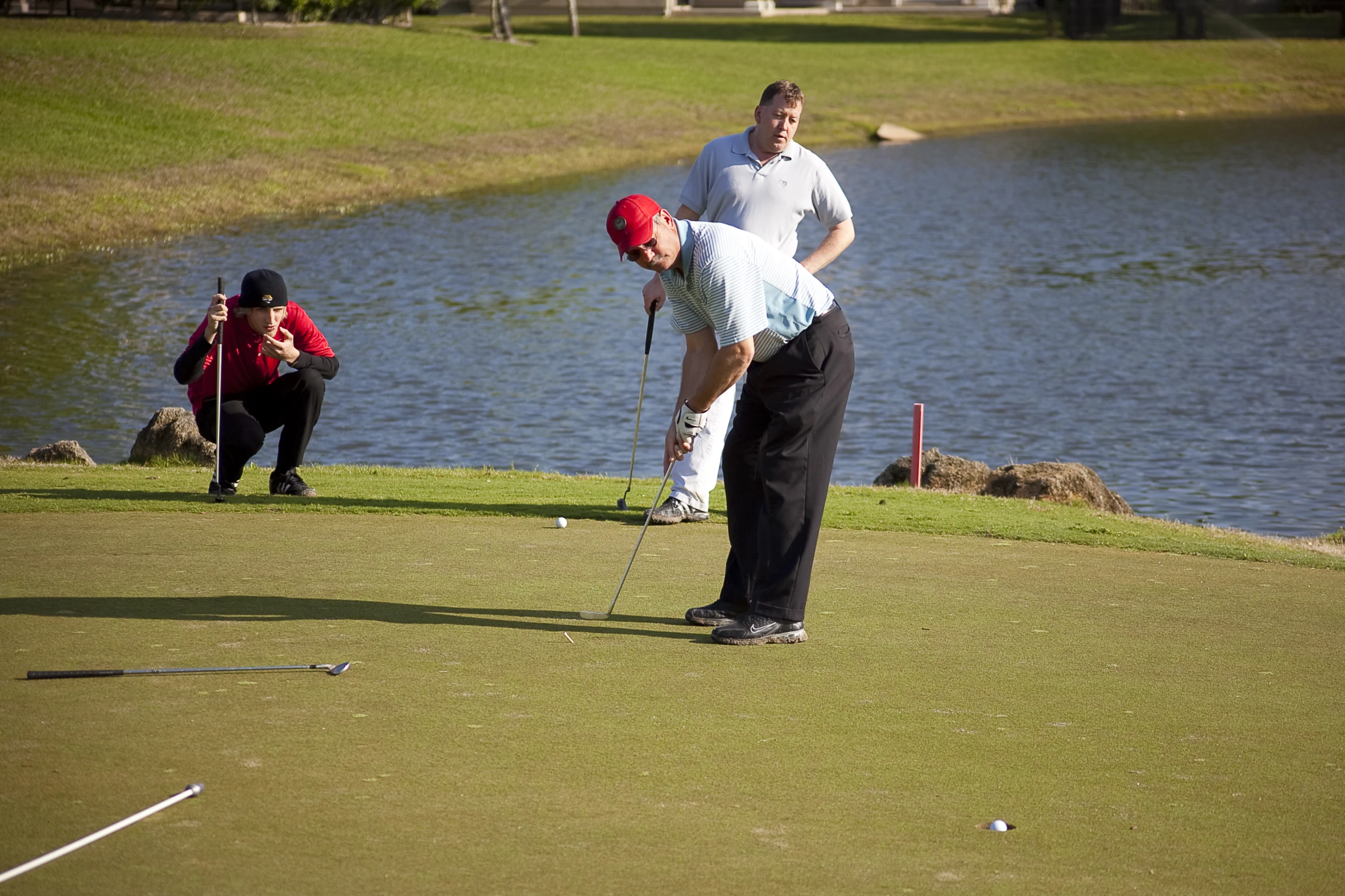 a person hitting a golf ball while on a green