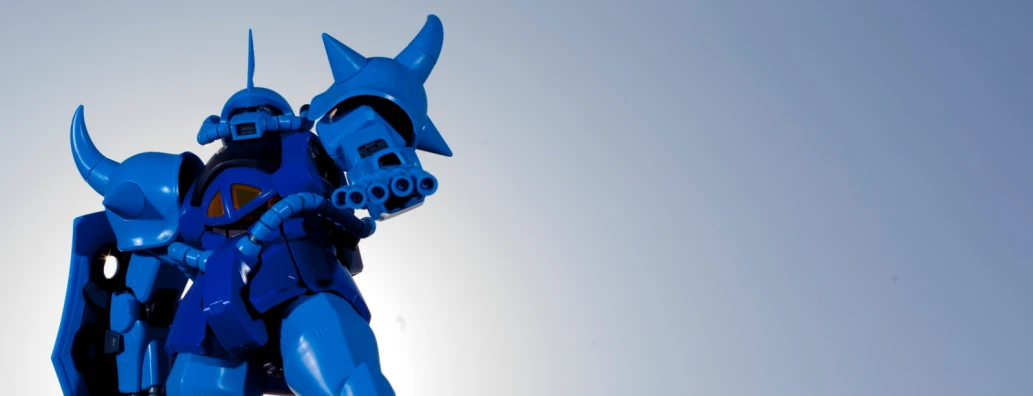 a giant plastic blue robot is standing up against a gray sky