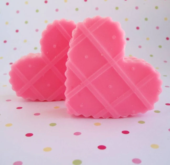 two heart shaped soaps are sitting on a polka dot table