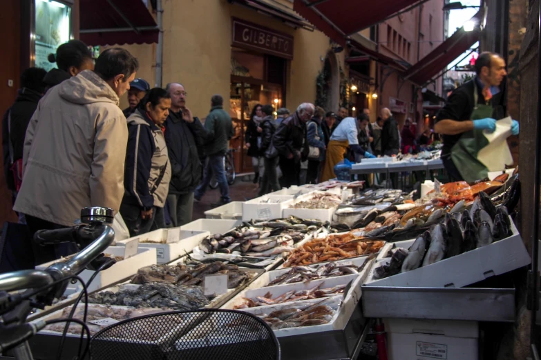 several people and a bicycle standing at a market