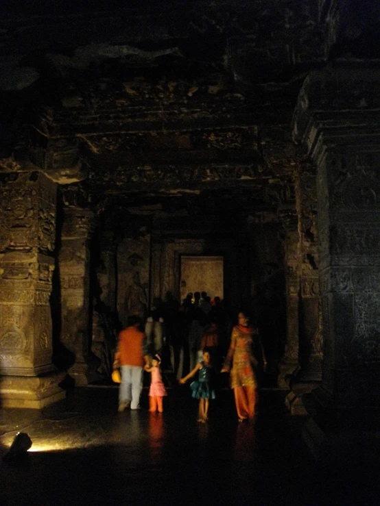 people stand in an underground, dark structure