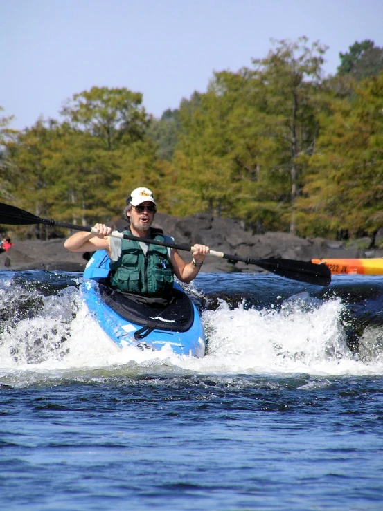 a man in a boat, riding along a body of water