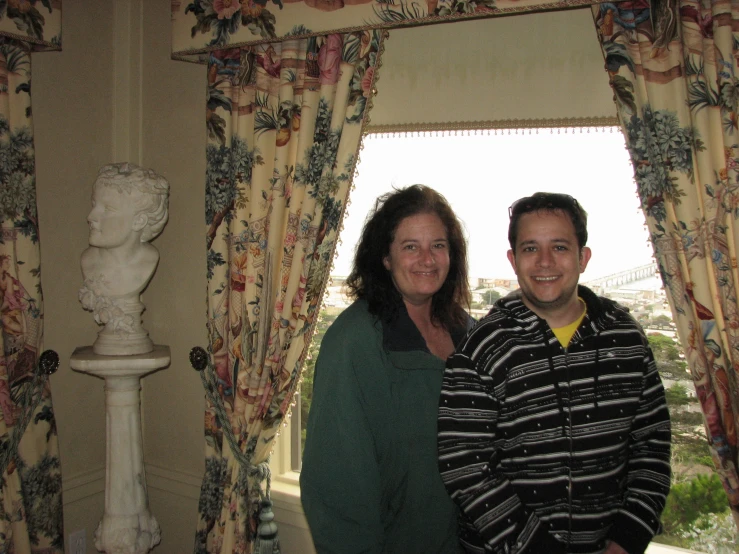 a man and woman posing for a picture with curtain around them