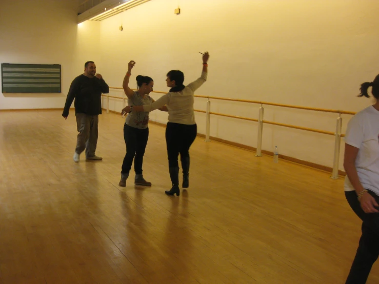 three people standing in an empty room with one holding her hands up