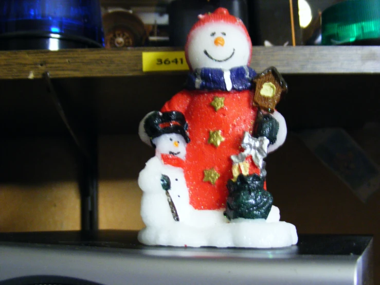 a white and red snow man figurine with a child