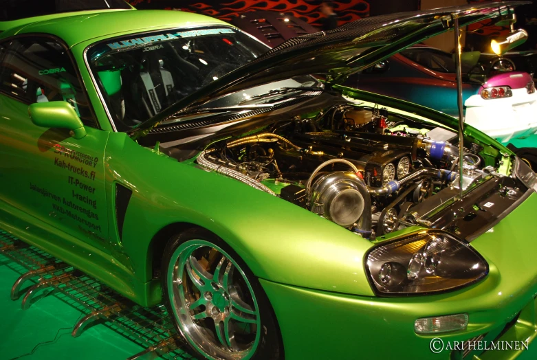 a green sports car with it's engine in the hood