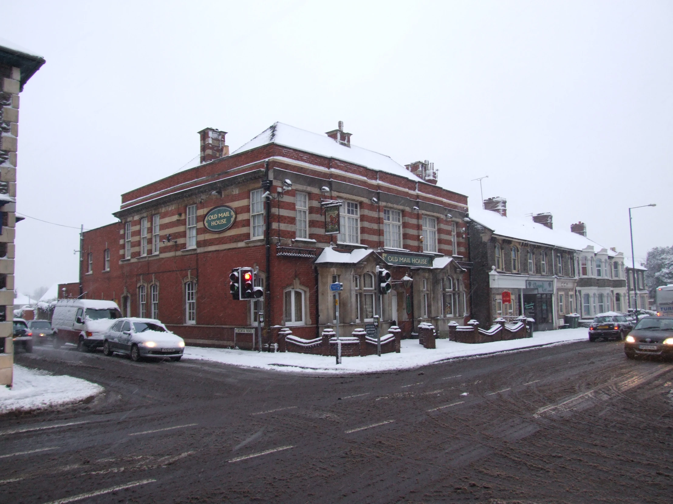 an old building sitting on the side of the street covered in snow