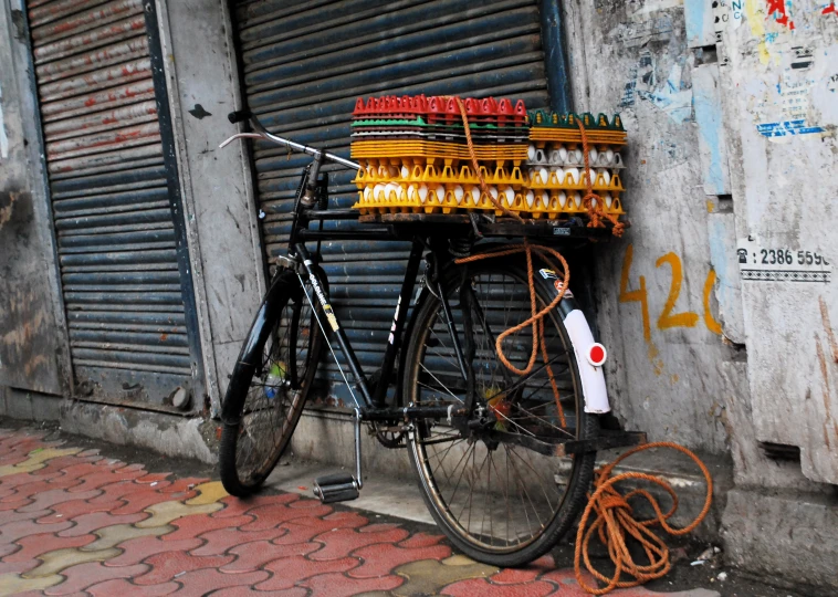 the old bicycle has four bottles of wine on it