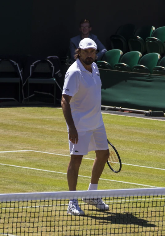 a man standing on a tennis court holding a racquet