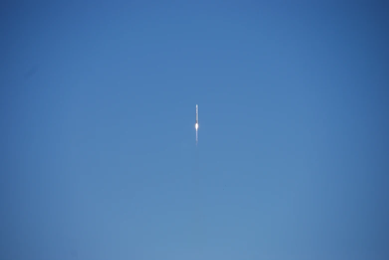 an airplane flying high in the blue sky