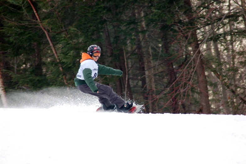 snowboarder with green jacket coming down the hill