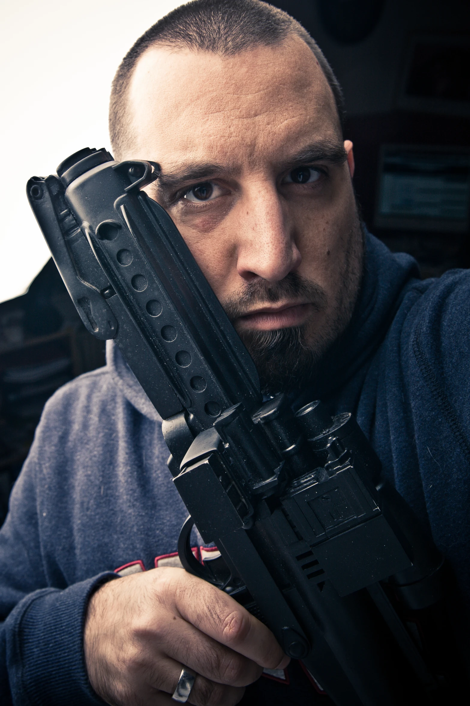 a man in black sweater holding a gun
