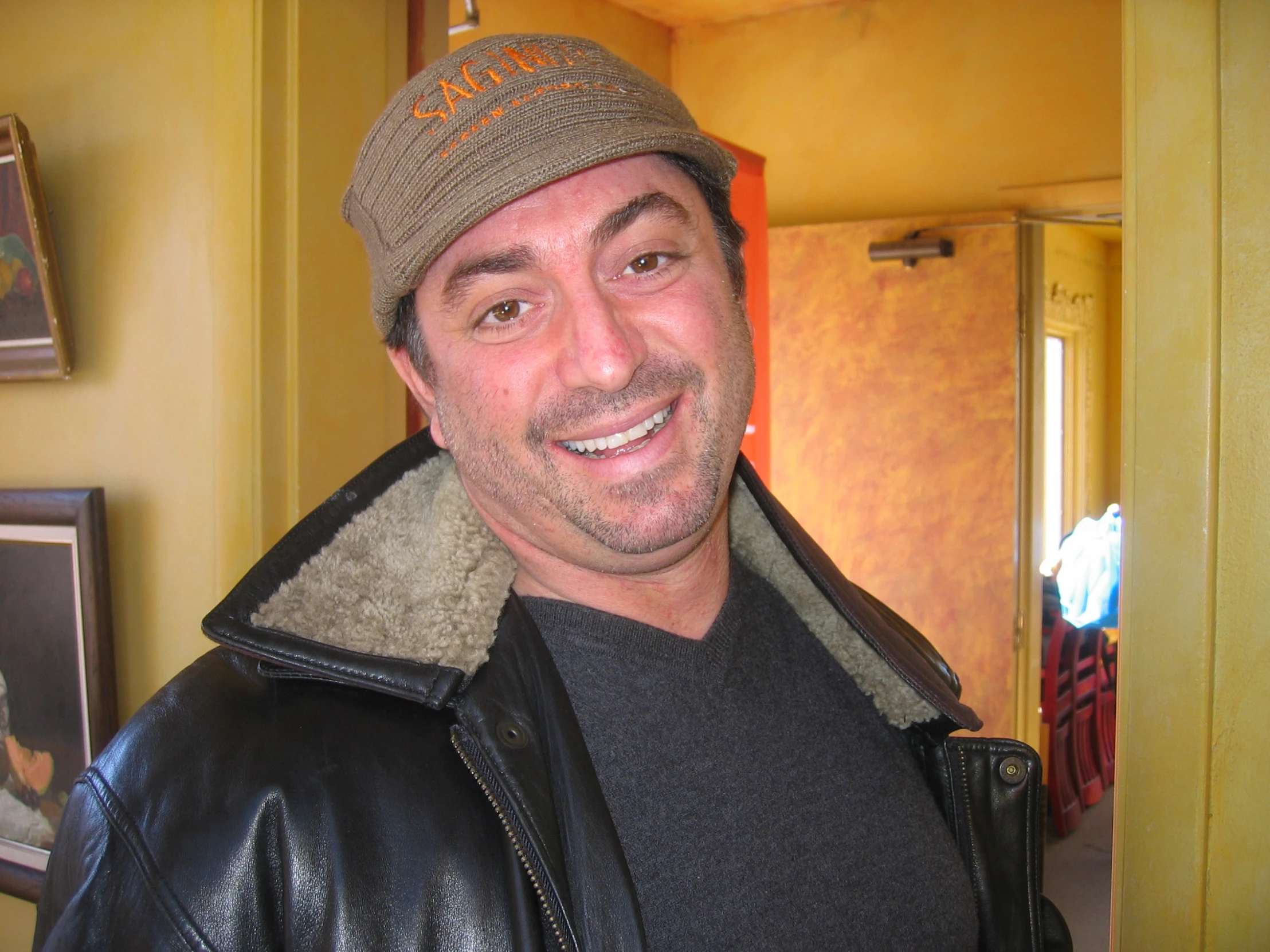 a man with a hat and scarf standing in a room