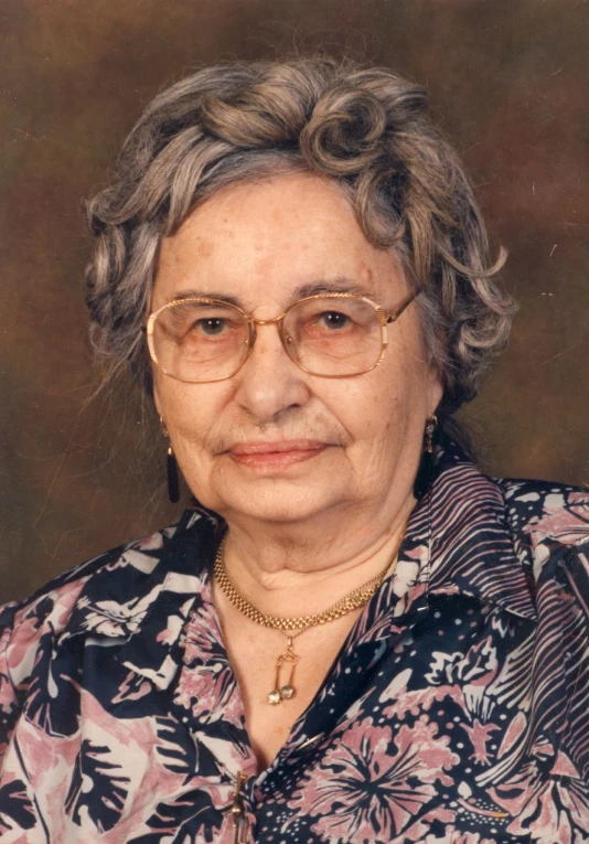 a portrait of a person with glasses wearing jewelry