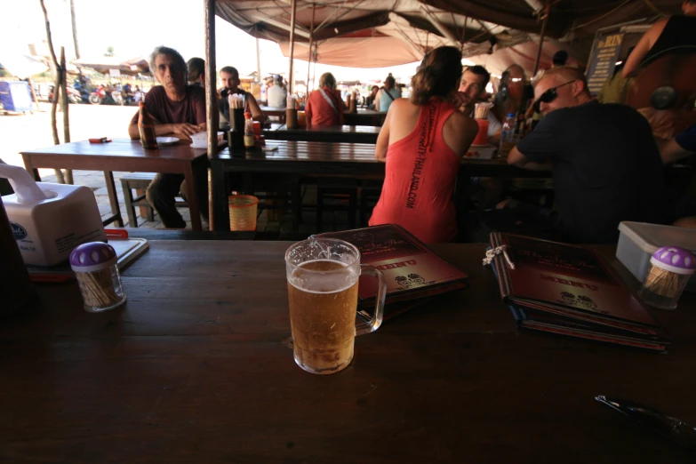 people sitting at tables in an outdoor eating and drinking area