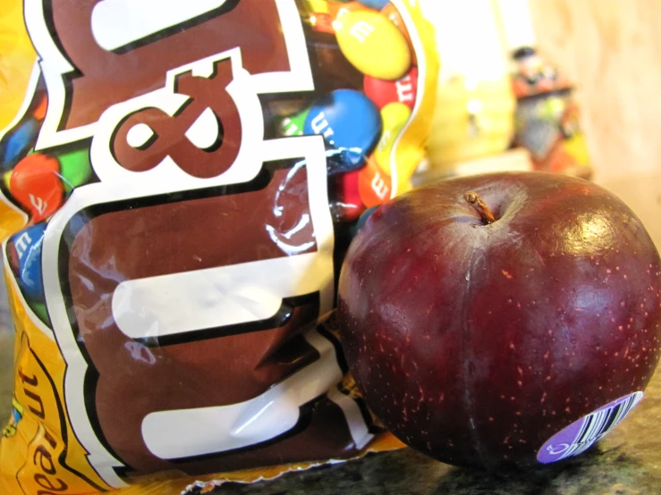 an apple next to a bag of chips and an apple