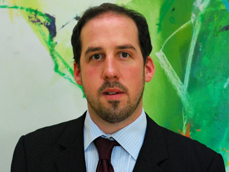 a man in suit and tie looking at the camera