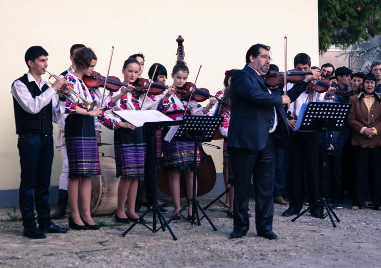 a man standing in front of a orchestra of musicians