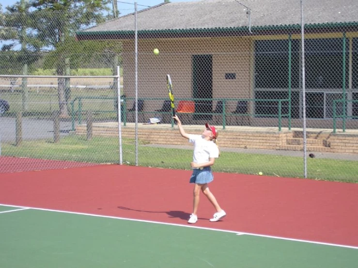 a tennis player playing on the court with the ball in the air