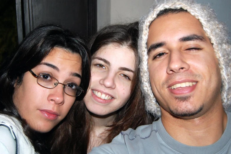 three people are smiling together in front of the camera