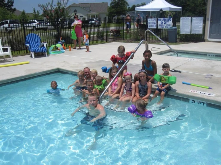 there is many young children playing in the pool